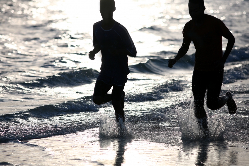 Two people running on a beach
